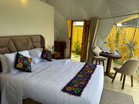 Cama queen con almohadas andinas y vistas panorámicas